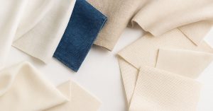 Embroidery fabric samples including denim, cotton, linen, and aida cloth displaying different weaves and textures for machine embroidery projects