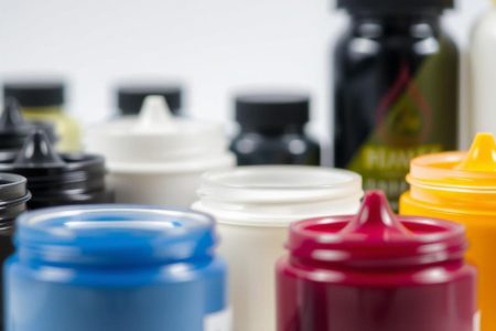 Various t-shirt printing inks in jars including plastisol, water-based, and specialty inks used for screen printing on fabric