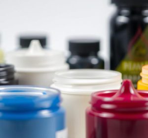 Various t-shirt printing inks in jars including plastisol, water-based, and specialty inks used for screen printing on fabric